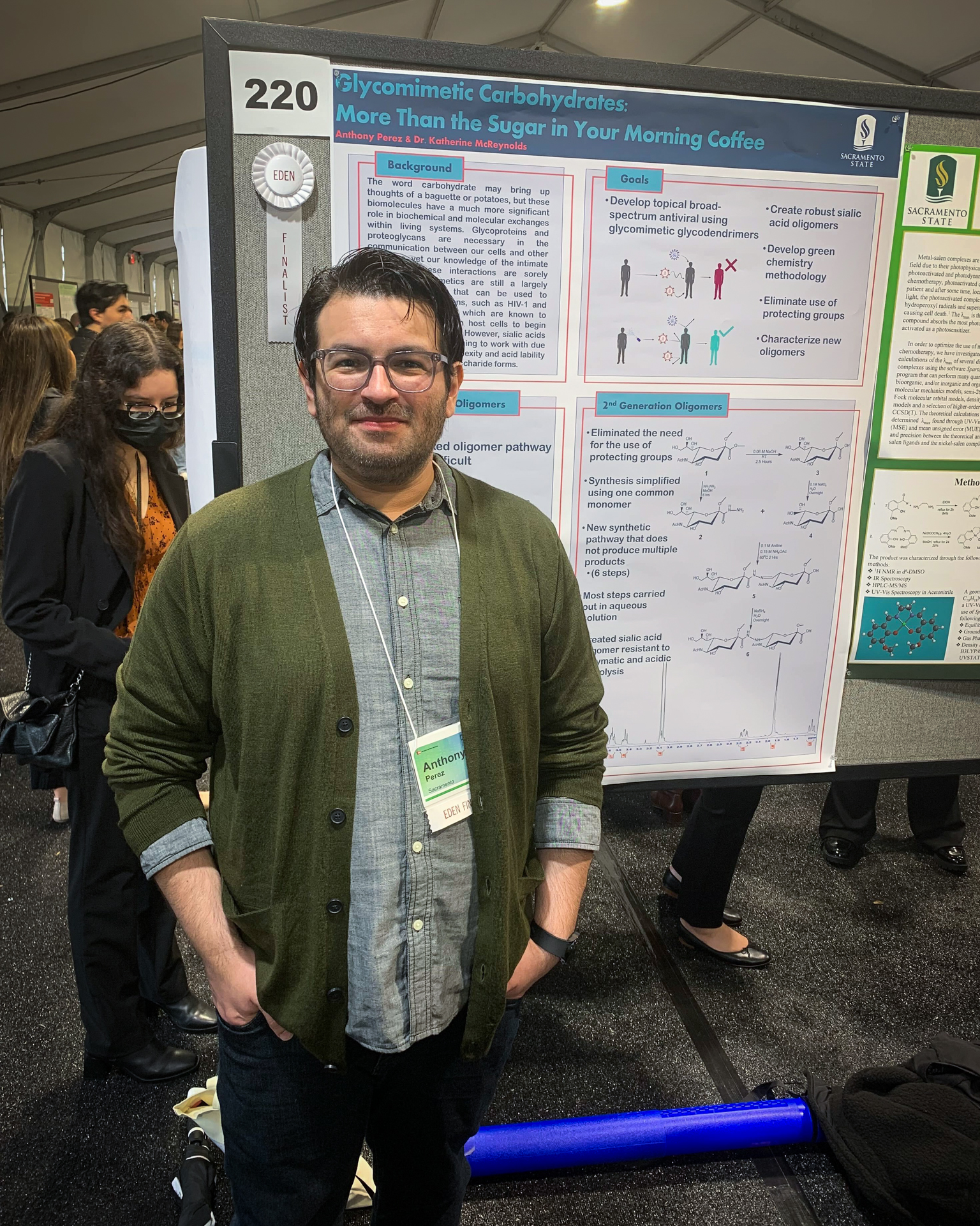 Anthony Perez poses next to his presentation poster of his award-winning research.