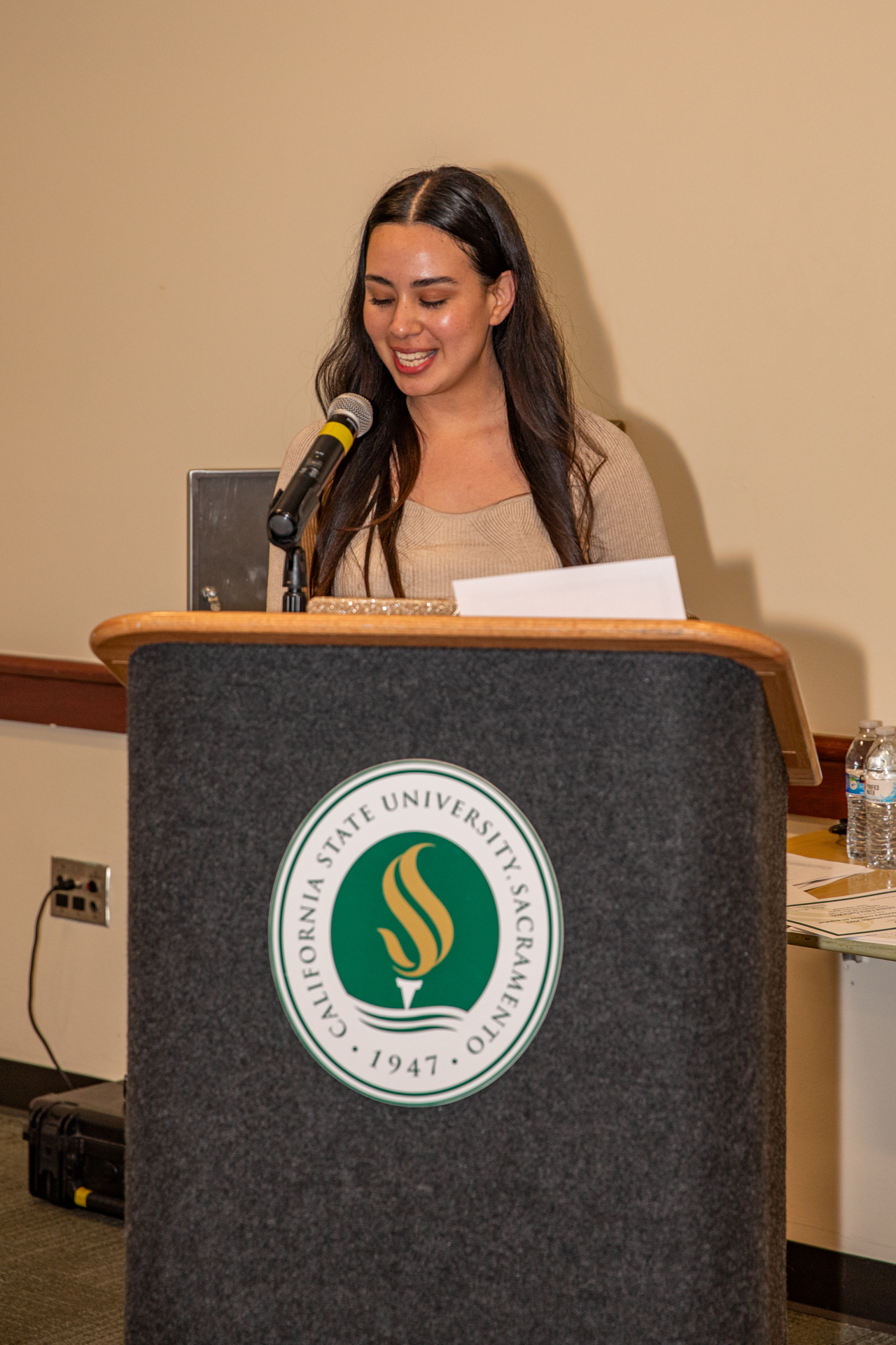 A Voces de Sacramento competition participant reads her submission at the podium.