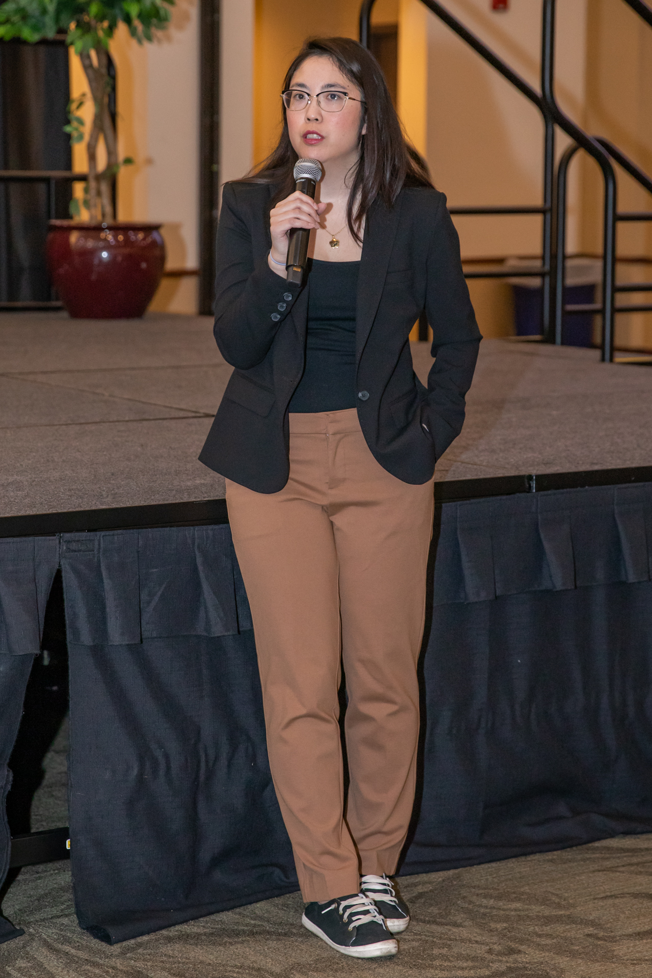 A speaker at a recent One Book Program event holds a microphone next to the stage. 