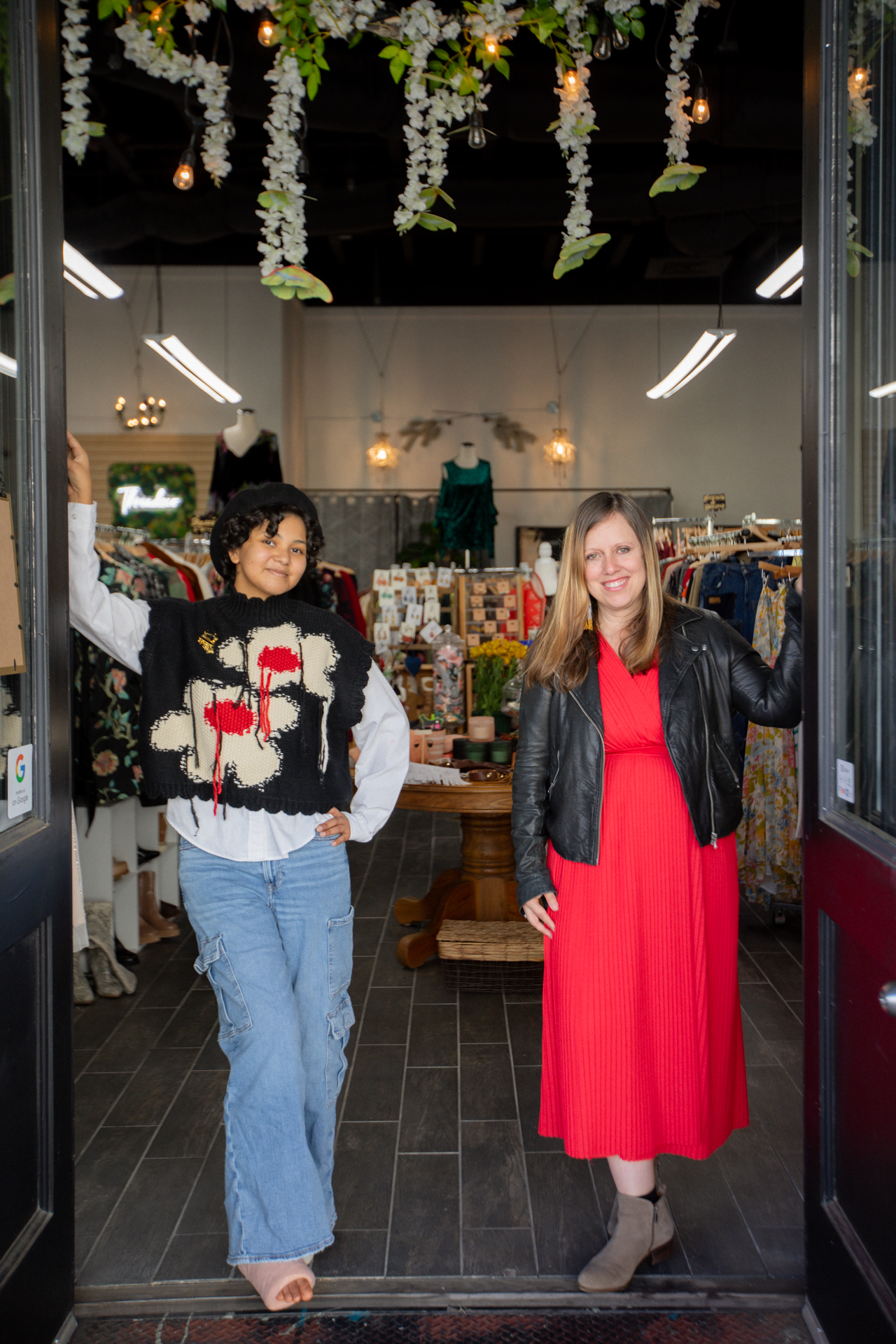 A Sacramento business owner and Sac State student pose in front of an Old Sac shop wearing festive clothing..