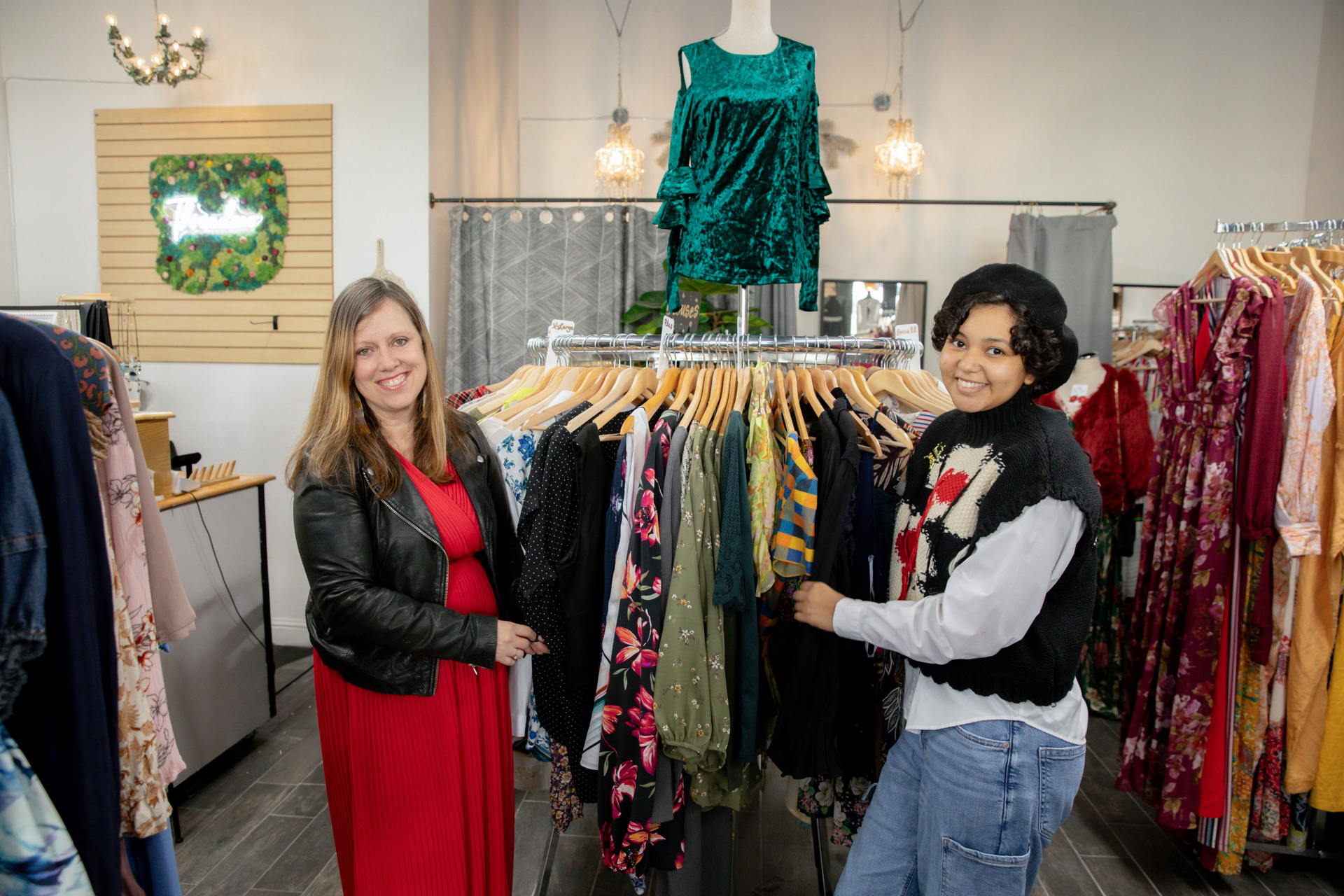 A store owner and a Sac State student who has been working at her business show off clothing in the Old Sacramento shop.