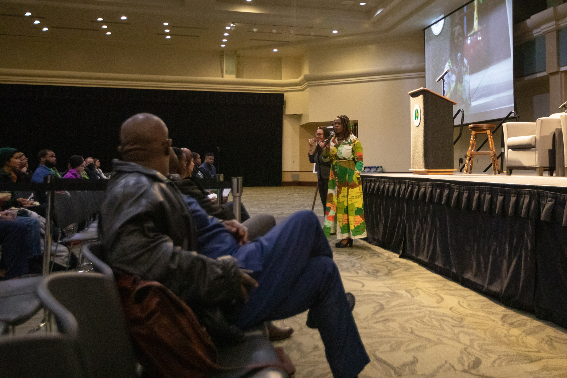 Sac State campus community members speak into a microphone at a forum. 