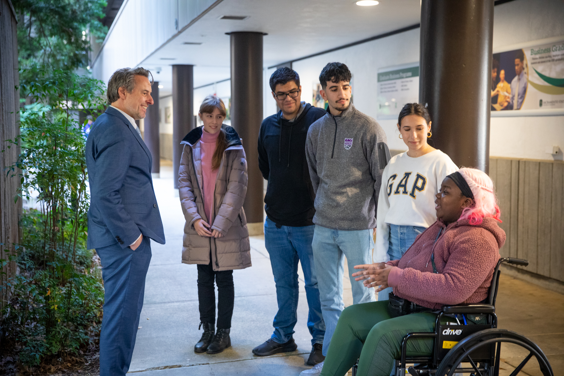 Sacramento State's new dean of the College of Business talks with students in Tahoe Hall on campus. 