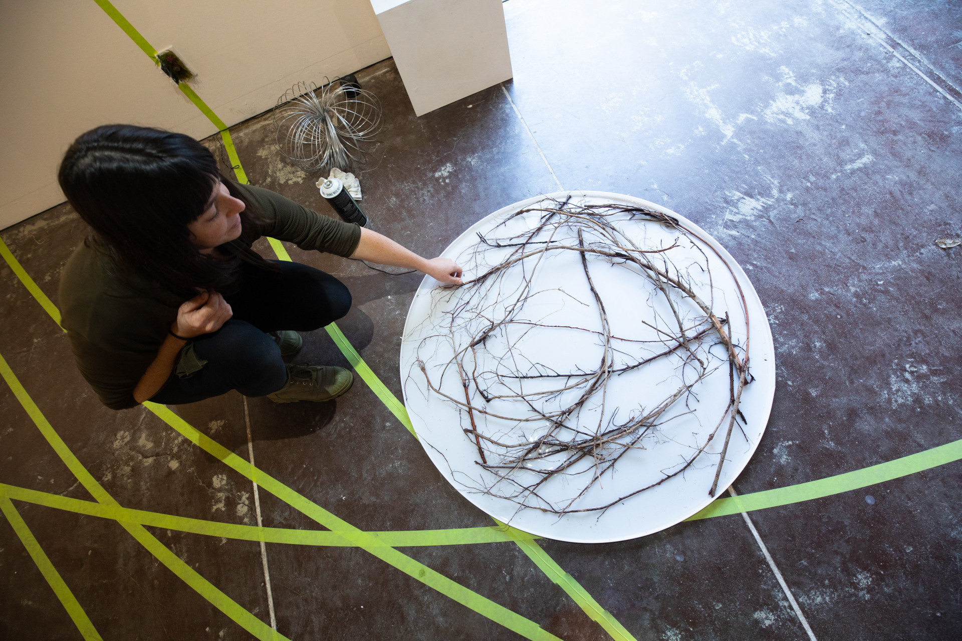 A "Pulse" exhibit artist works with her art piece on the floor of the Else Gallery at Sac State.