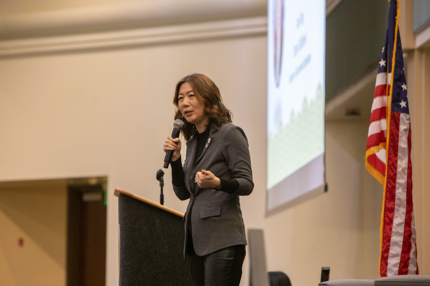 Amy Tong speaks into a microphone on stage during APIDA College Day.