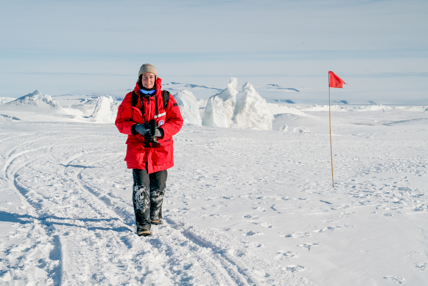 Sac State Professor Kathy Kasic holding a film camera in the icy snow of Antarctica during the filming of her documentary.