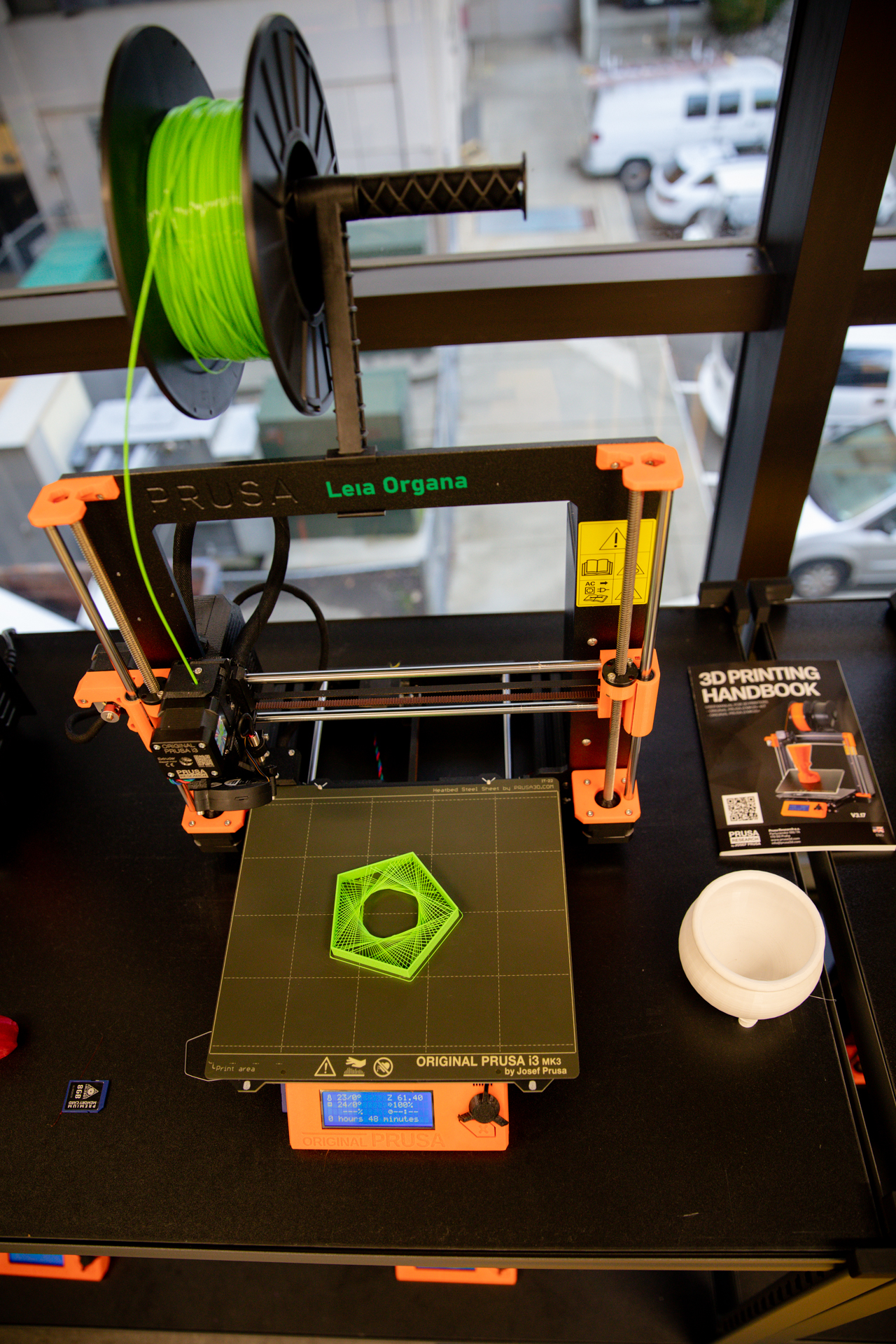 A 3D printer in action as it prints a lime green design.