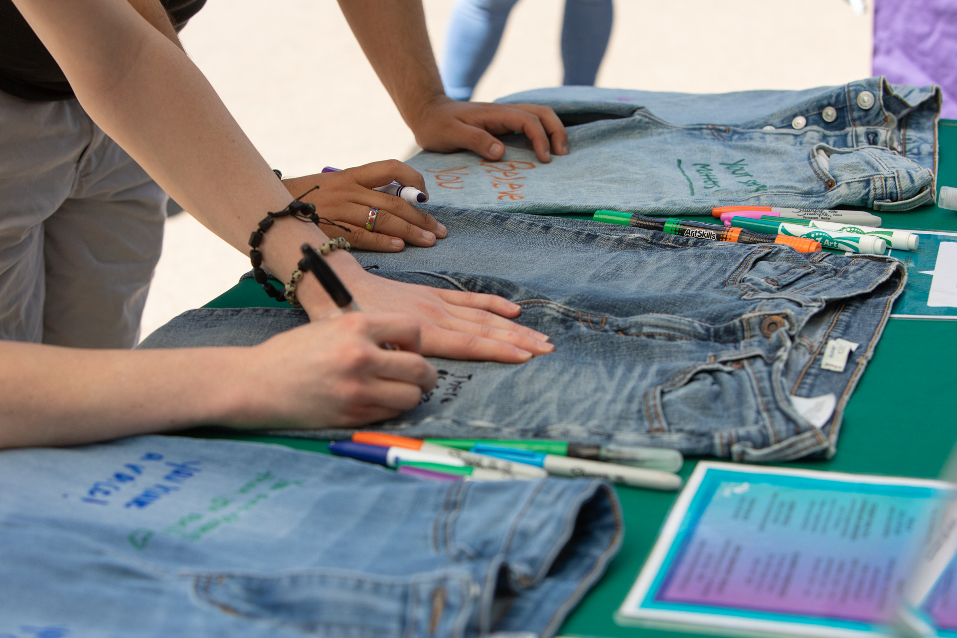 Sac State students wrote messages of support for survivors of sexual violence on pairs of jeans during the Denim Day event.