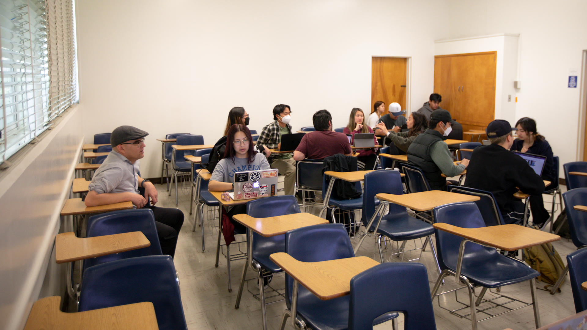 Asian American Communities students work on projects in a classroom.