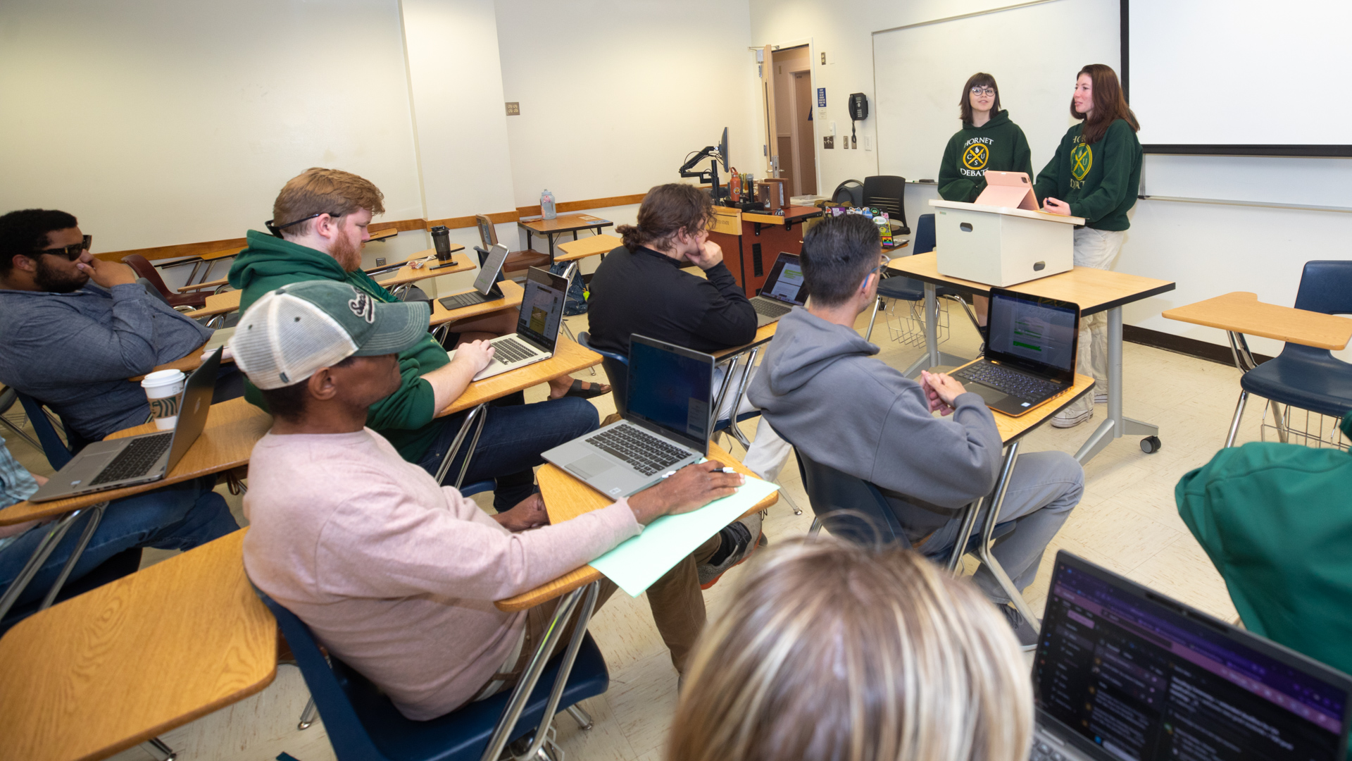 Sacramento State Debate Team students practice public speaking in a classroom. 