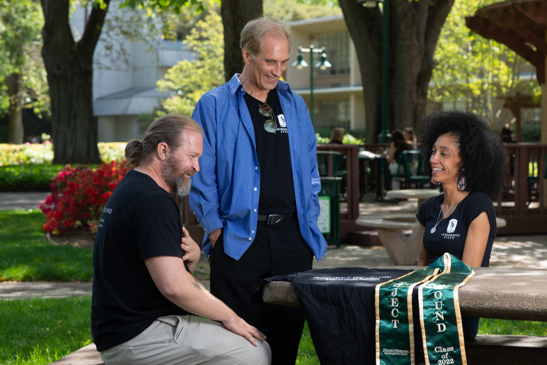Member of Sacramento State's Project Rebound meet for a chat at a picnic table on campus.