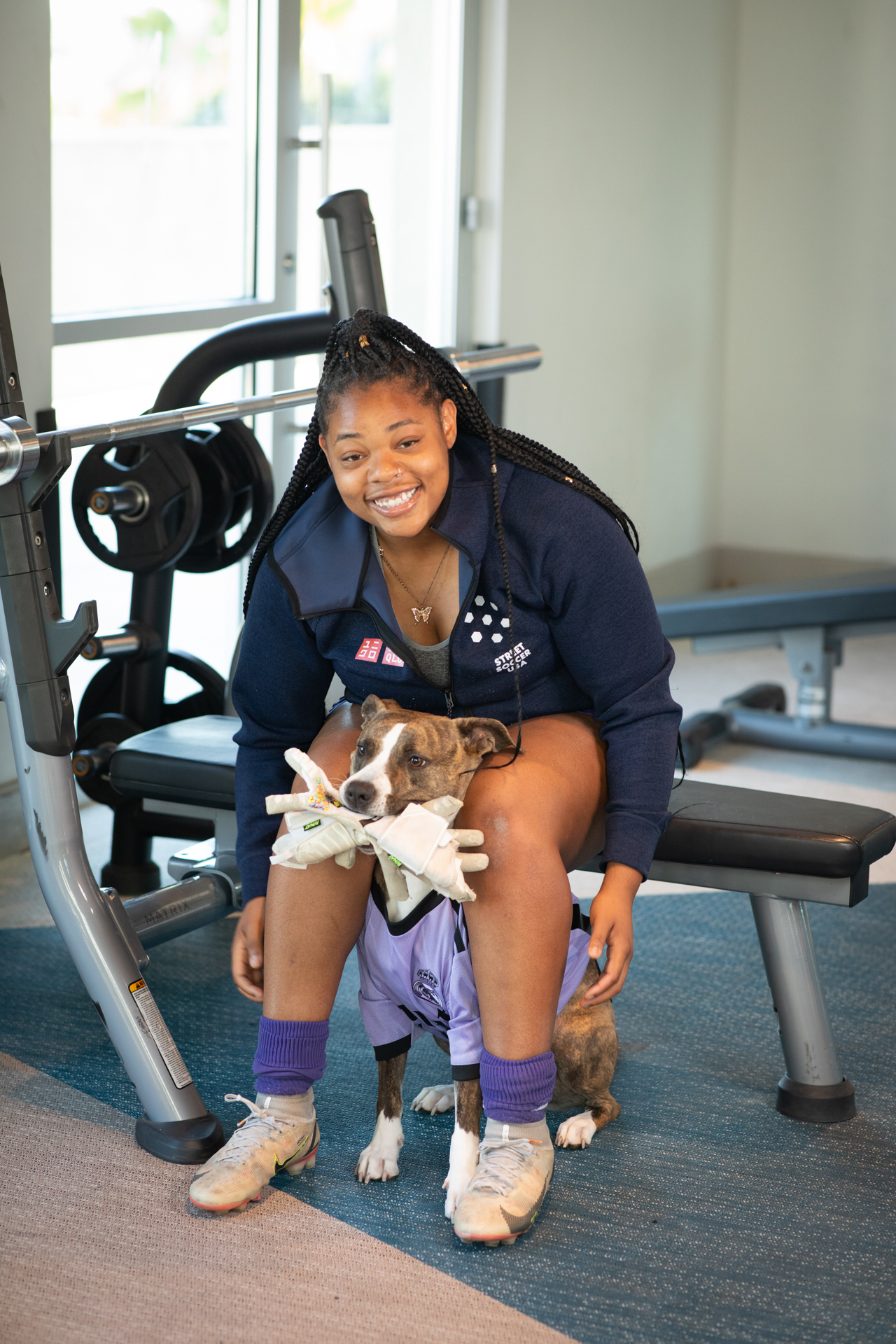 A woman and her dog in the gym. 
