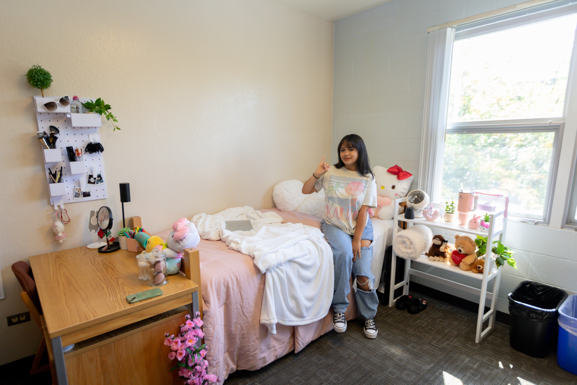 A student shows off her decorated room at a residence hall in Sac State's North Village.