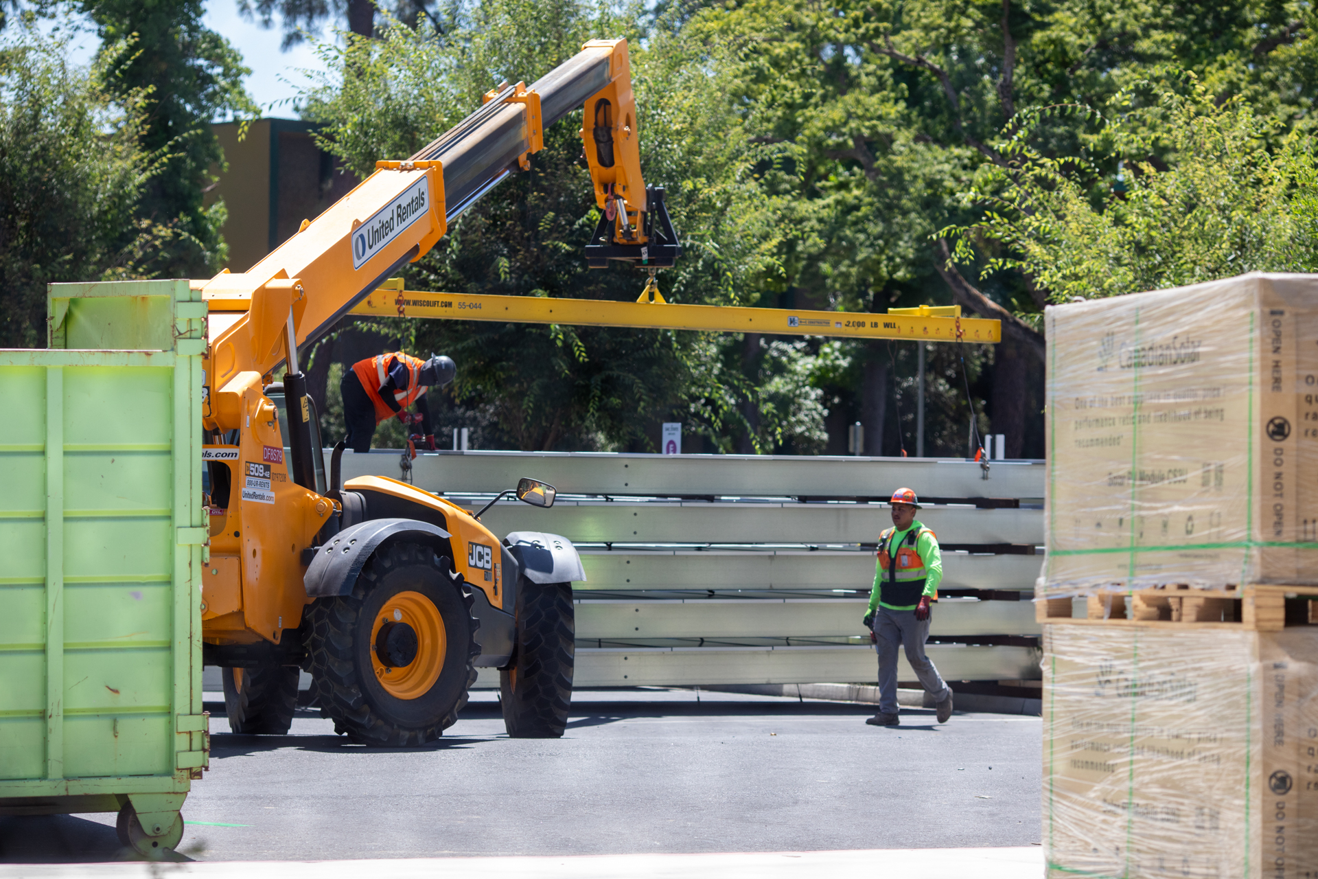 Heavy equipment prepares solar panels for installation in a parking lot at Sacramento State.