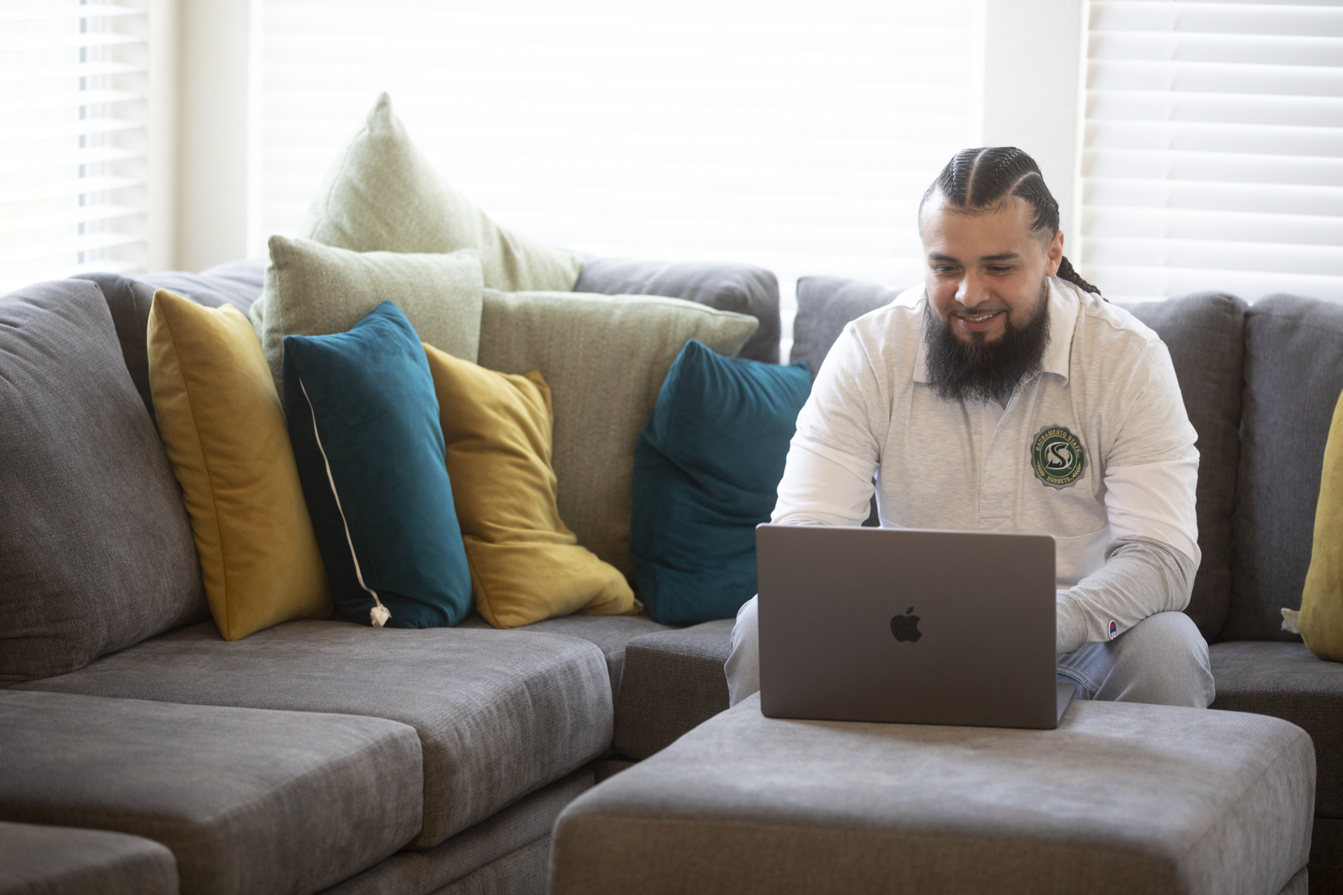 Jon Hernandez, on a couch, using a laptop.