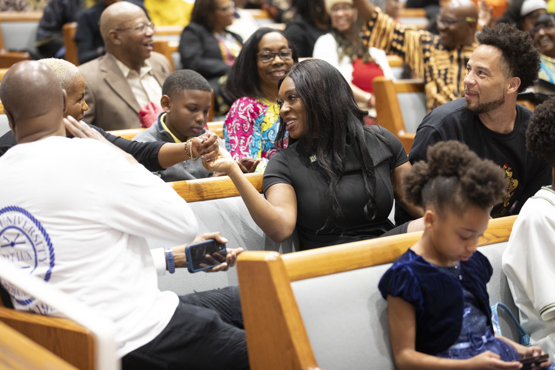 Idara Essien-Wood holds the hand of a churchgoer during Super Sunday.