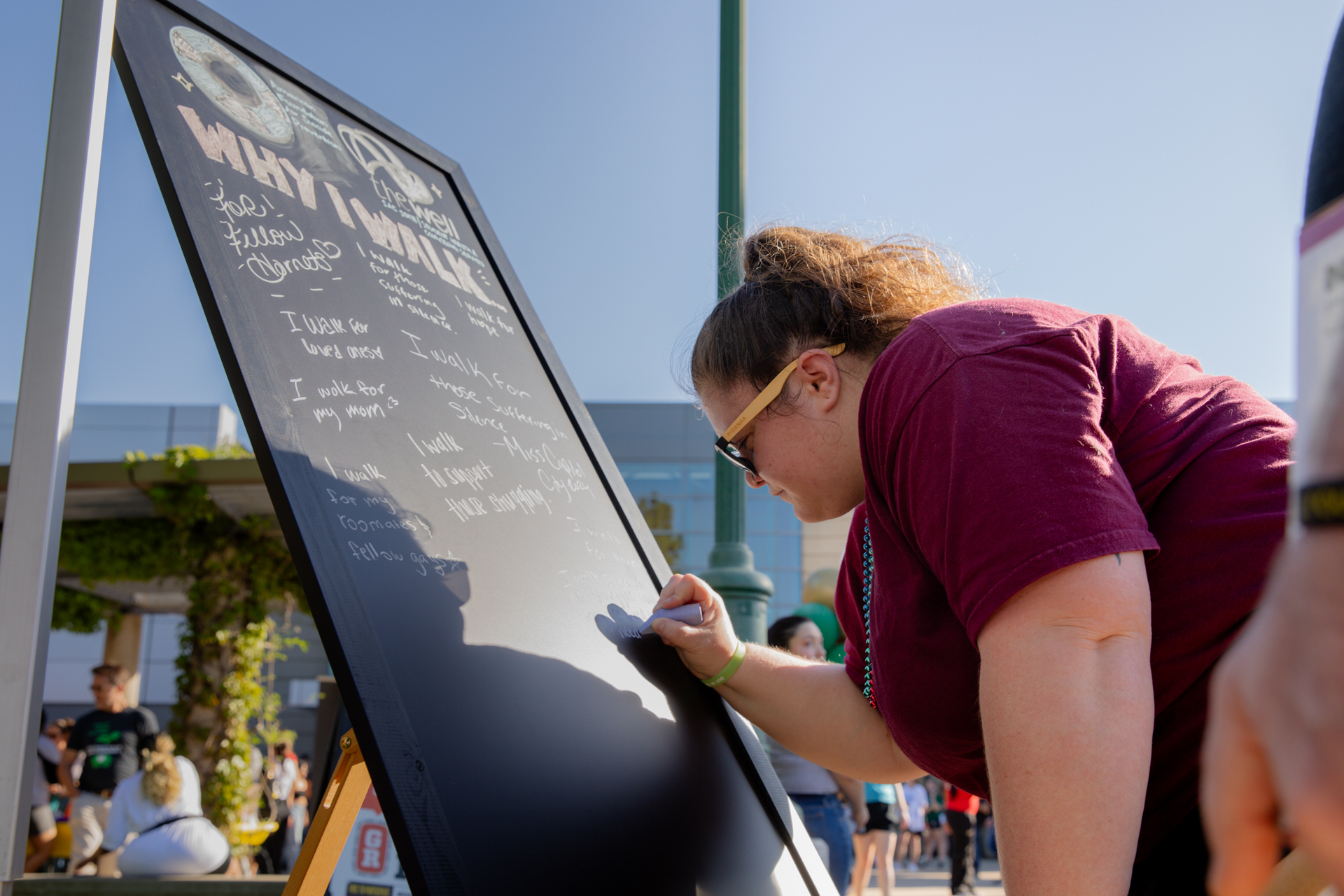 An Out of the Darkness participant writes a message on a chalkboard.