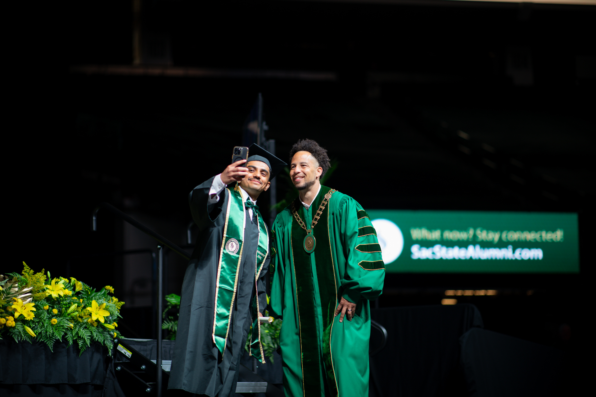 President Wood takes a selfie with a graduate from the Commencement stage.