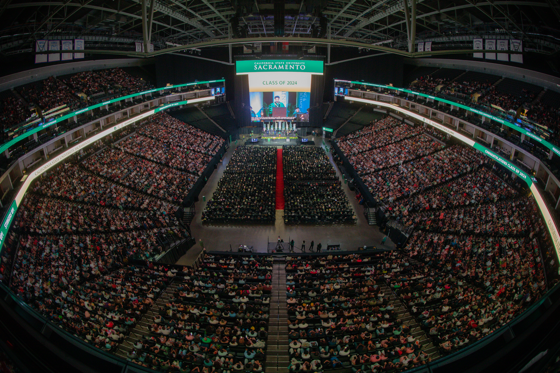 A wide view of thousands of graduates and guests gathered inside Golden 1 Center for Commencement.