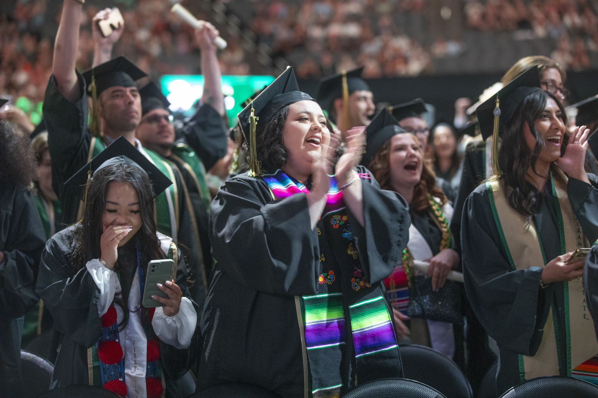 Gradutes in academic regalia celebrating during Commencement.