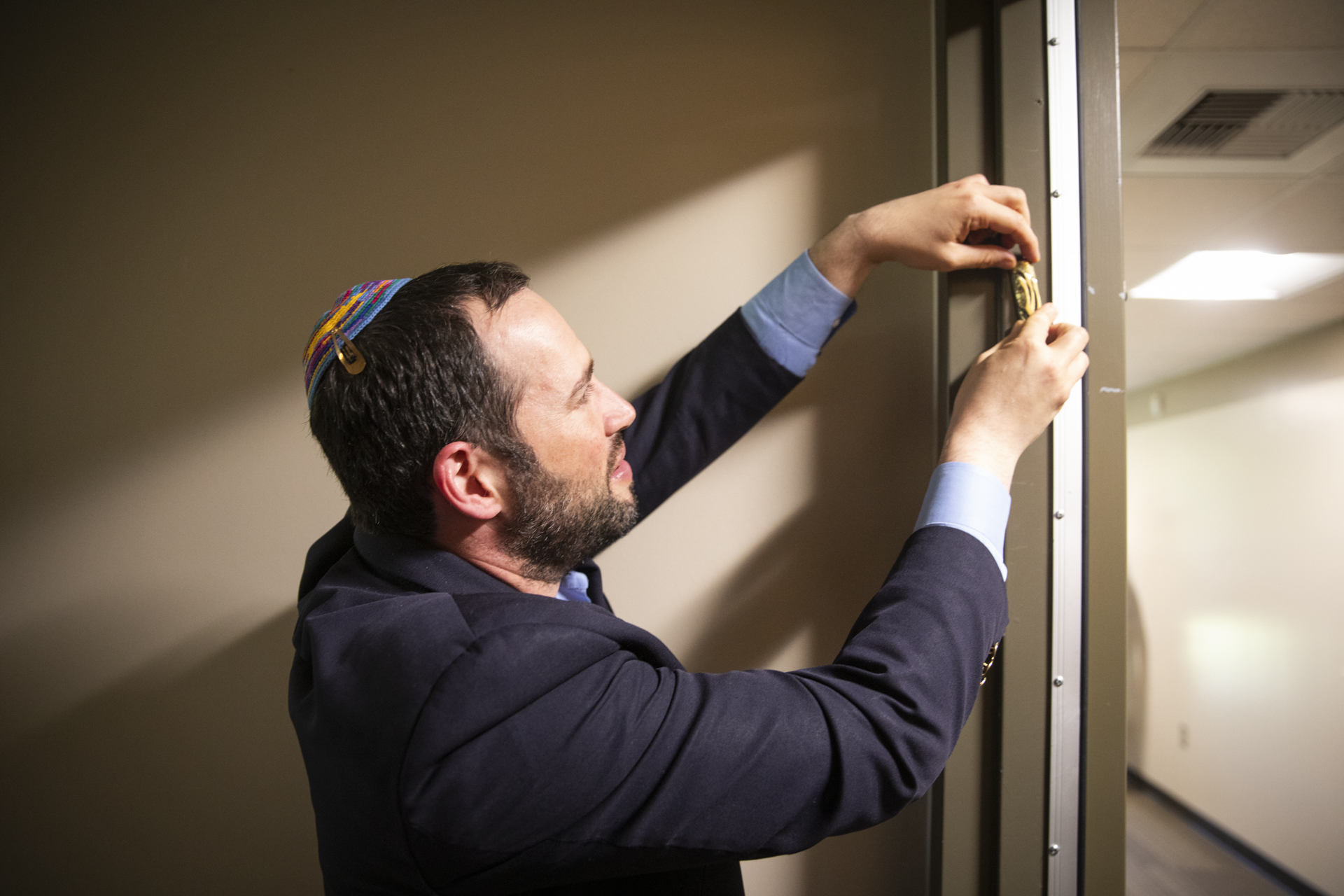 Rabbi Ben Herman hanging a mezuzah on the doorpost of Sac State's new Jewish Life and Resource Center.