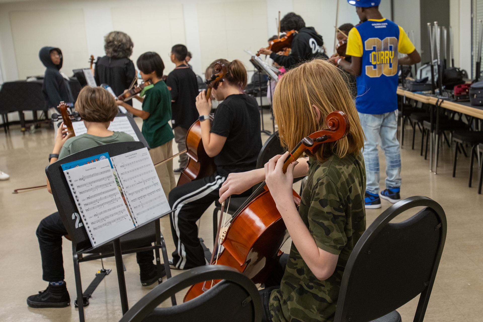 K-12 participants in the Sac State String Project practice on instruments in a campus music classroom.