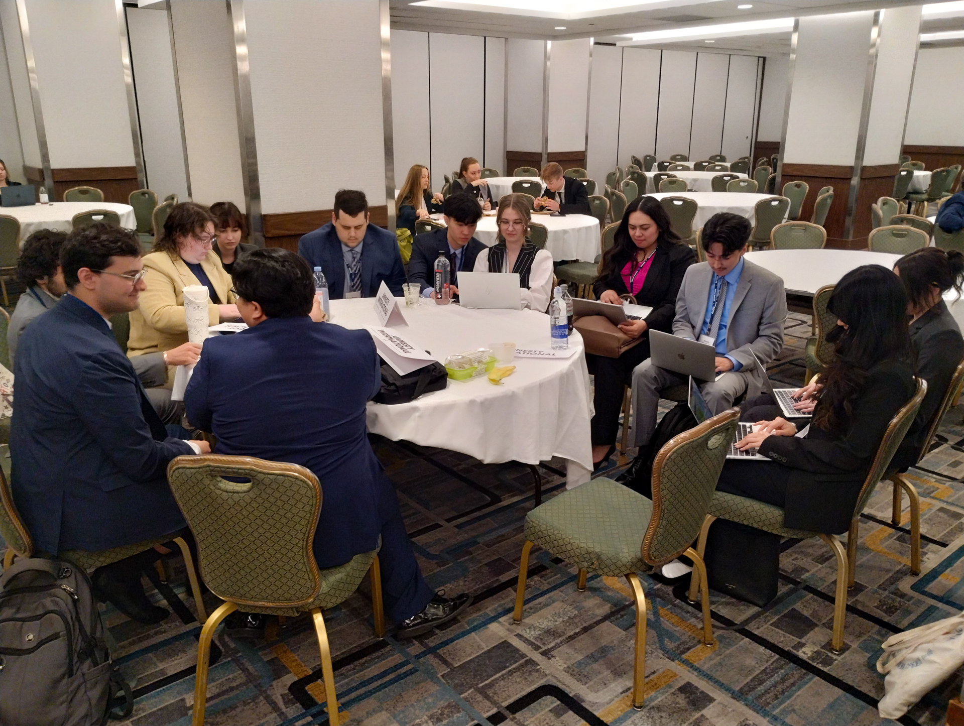 Sac State's Model UN team members work on their laptops and enjoy each other's company at the Model UN conference.