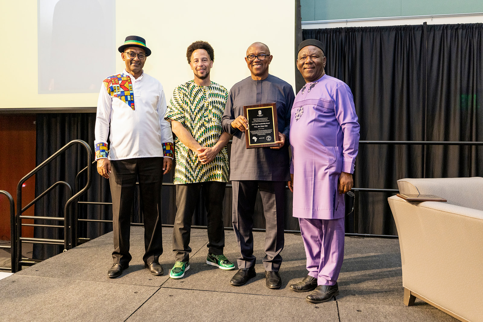 Peter Obi standing with Luke Wood, Ernest Uwazie and a third individual, posing for a photo.