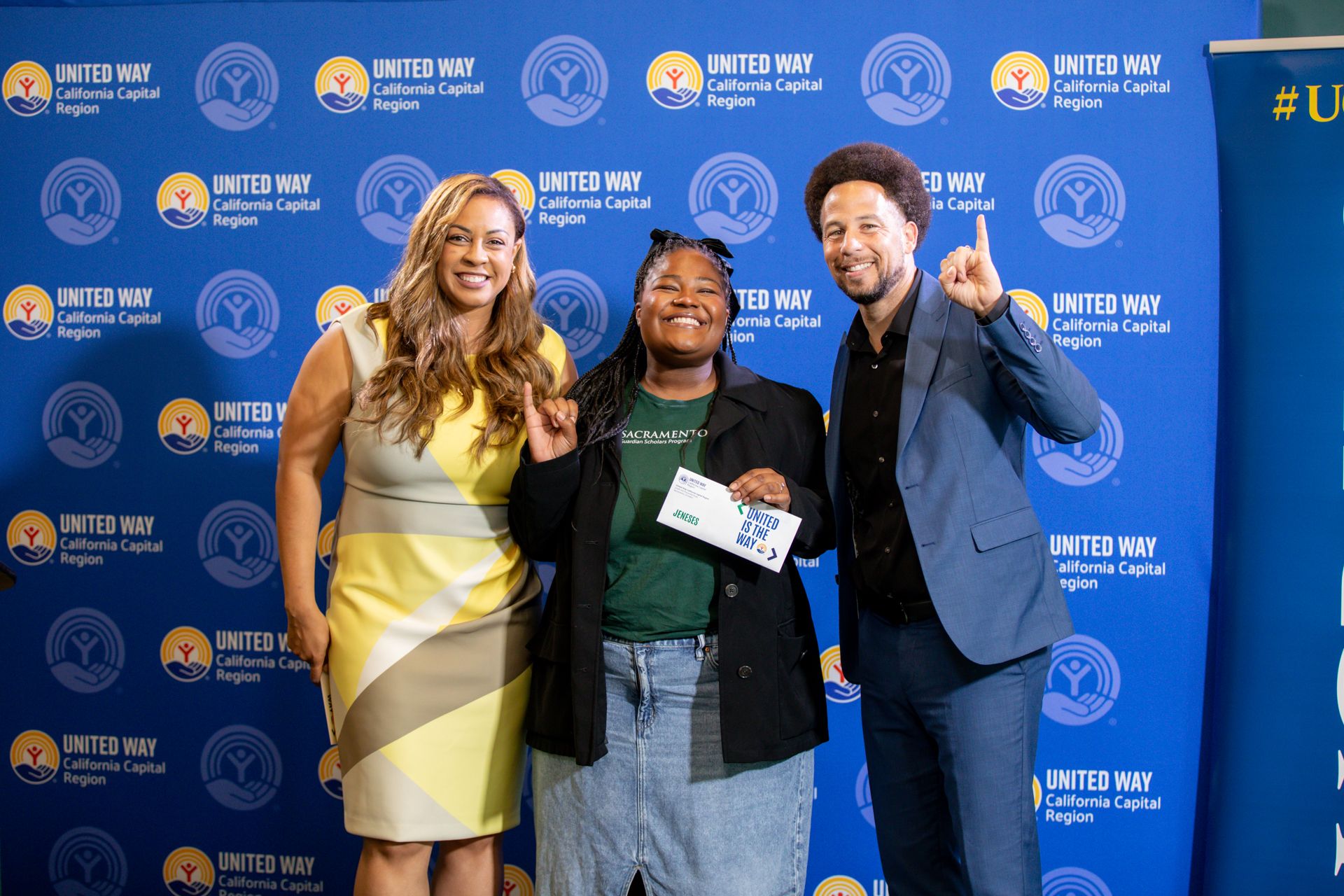 A Guardian Scholars student is presented a check by United Way's president and CEO and Sac State President Luke Wood as part of a guaranteed income program.