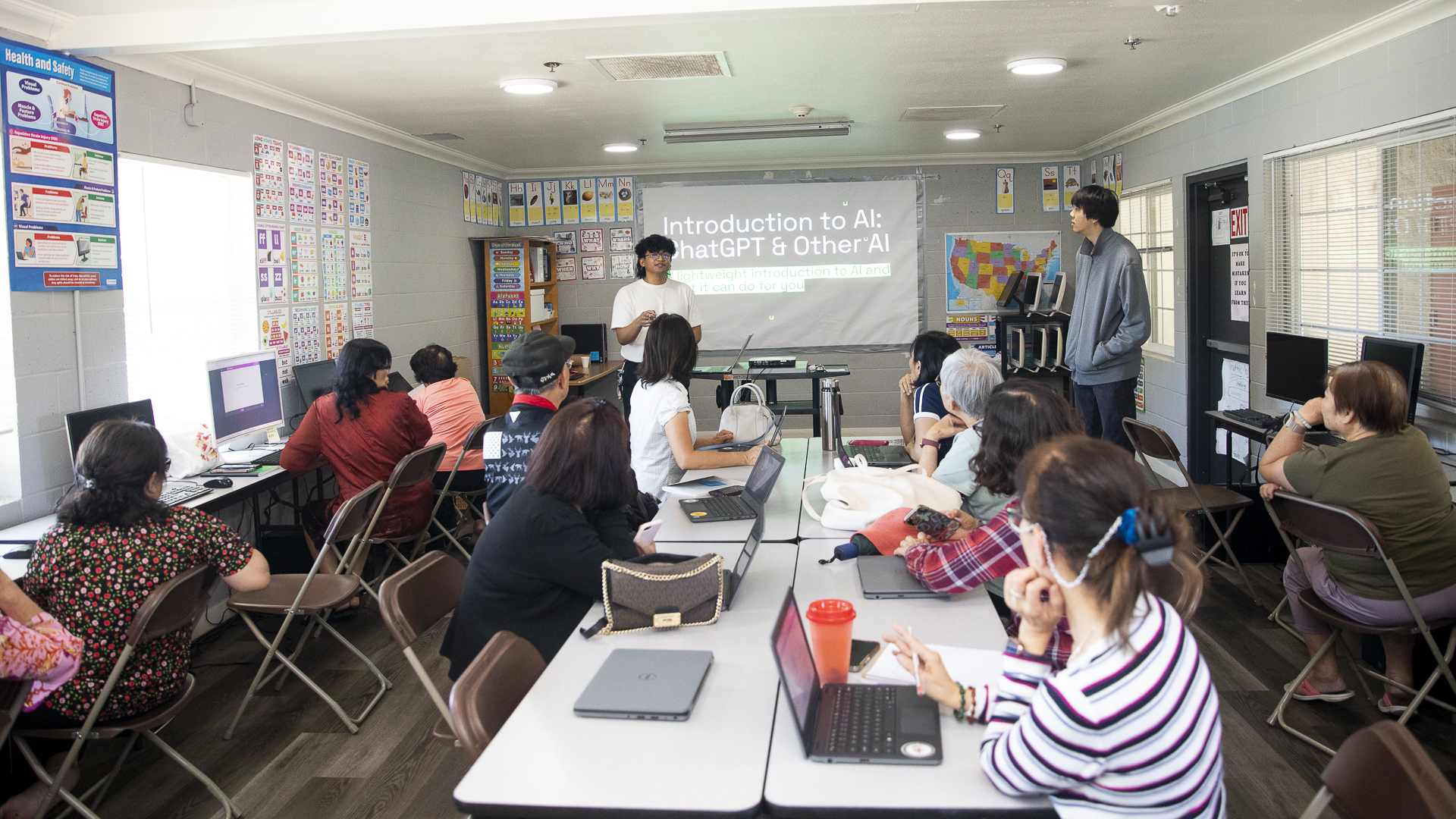 Students lead a community class, teaching local residents computer skills and how to use AI.