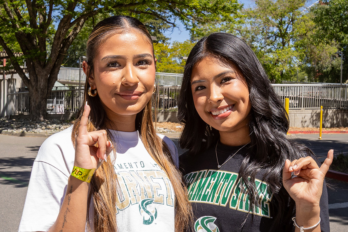 Two students give stingers up sign.