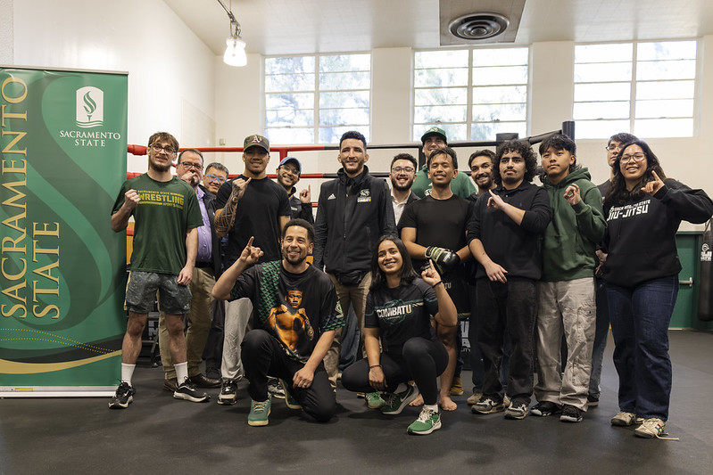 Combat U student-athletes and officials pose in group photo.