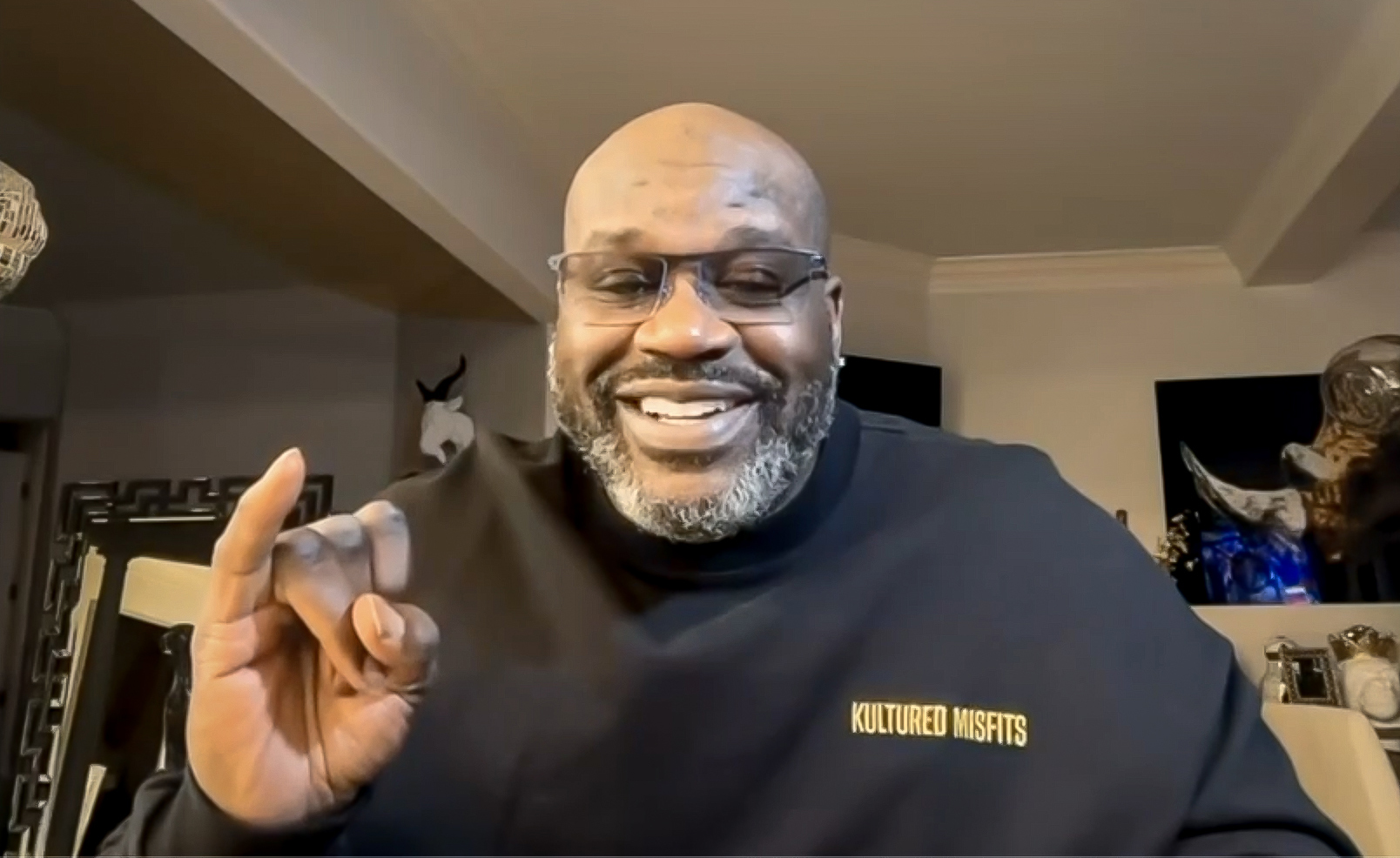 Screenshot of Shaquille O'Neal raising hand and pinky in Stingers Up sign.