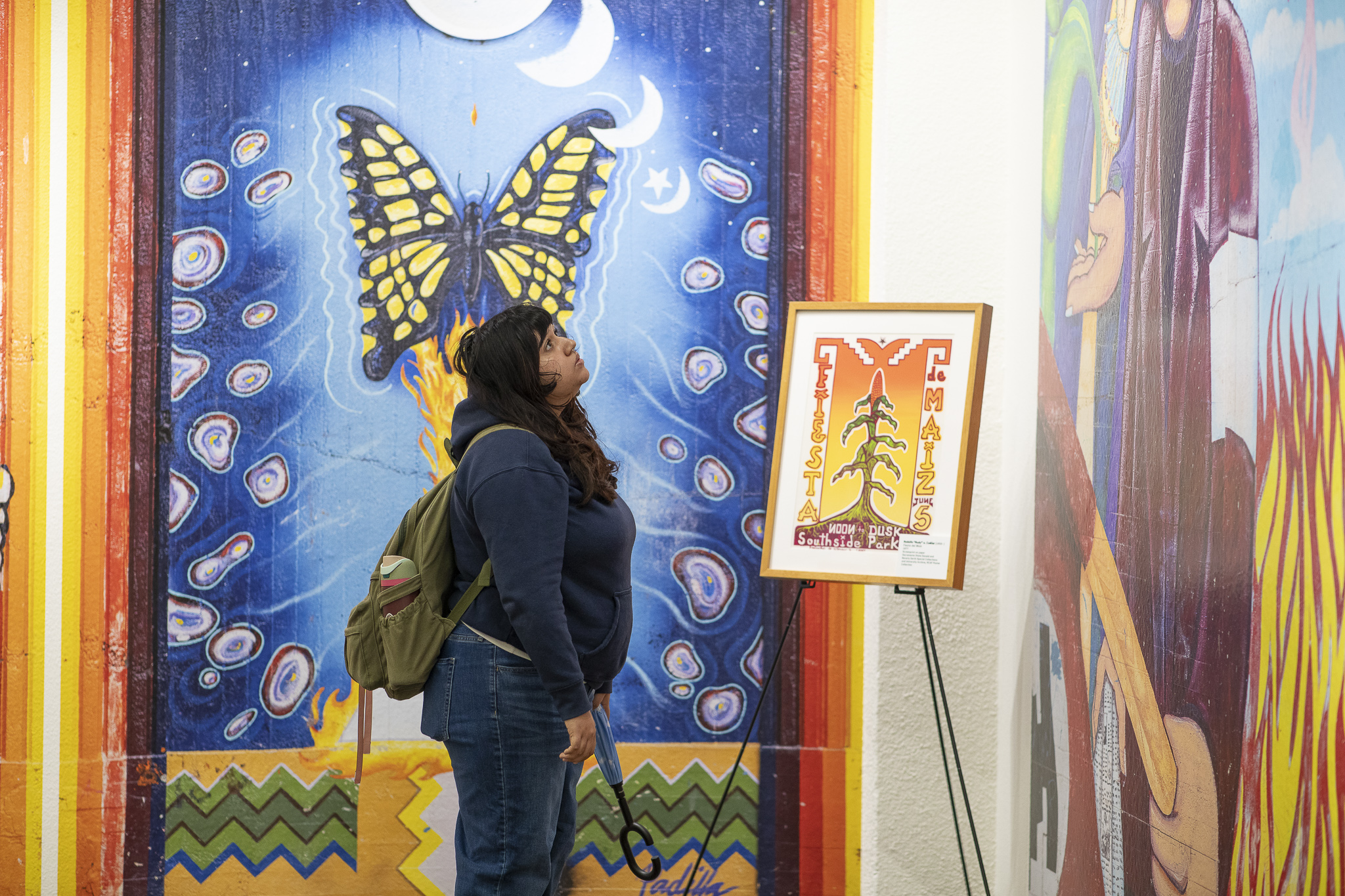 Woman examines large-scale, bold, colorful mural.