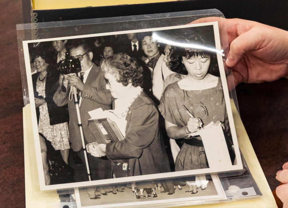 A black and white photo of Japanese American leaders receiving plaque.