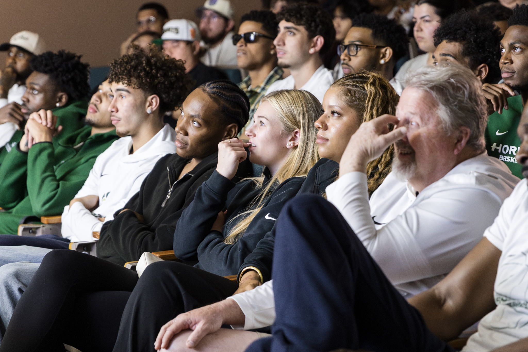 People in an audience watching movie premiere in an auditorium.