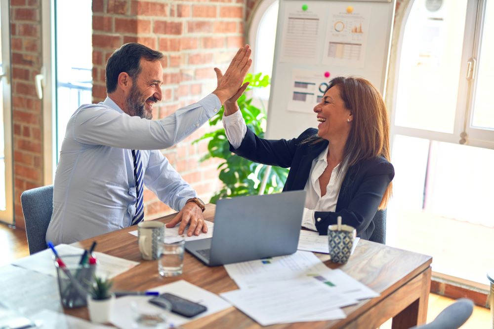 Two work colleagues giving each other a high-five