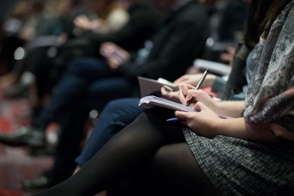 Close-up of a group taking notes in a meeting
