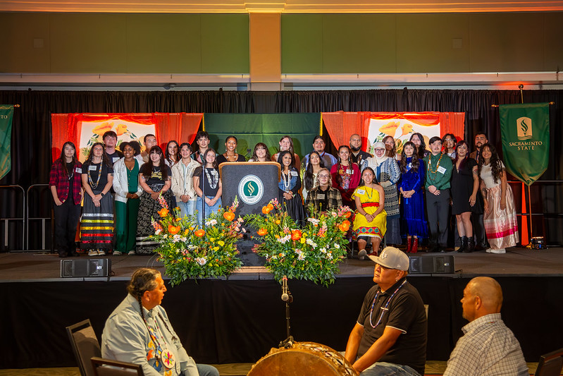 WNAC students on stage with elders in front of them before performing a ceremonial song