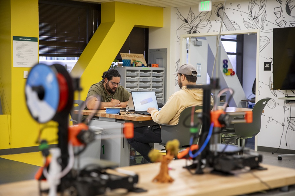 students sitting at table in a workroom