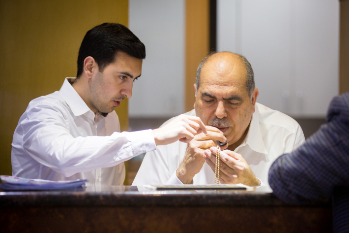 Ali Sharif (left) and his father, Mahmud Sharif, examine a piece of jewelry. 