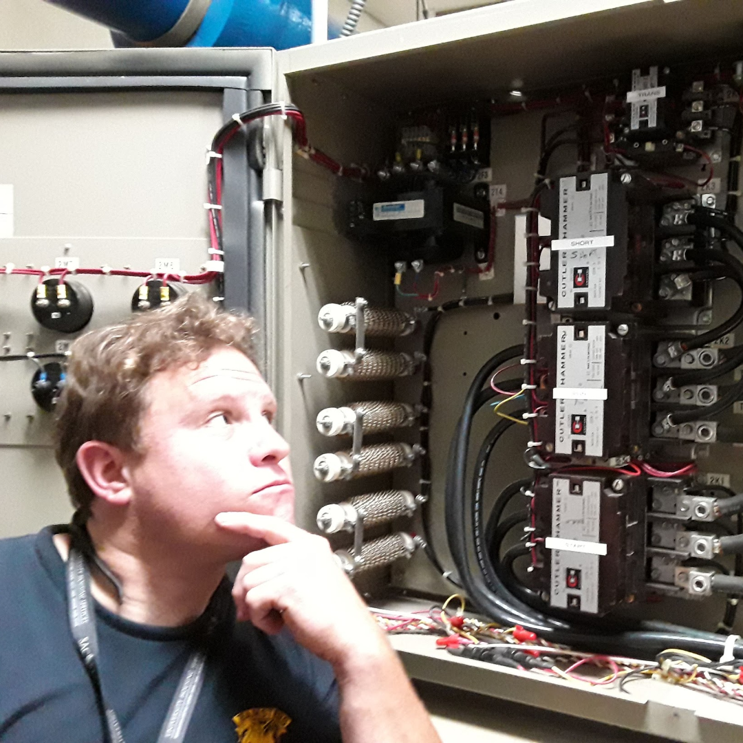 A photo of Kevin looking at an electrical panel