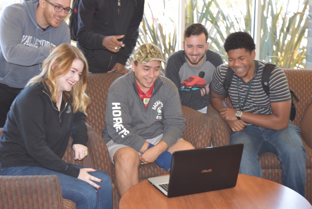 Students gathered around a laptop